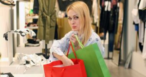 oung woman shoplifting in a boutique. About 30 years old, Caucasian blonde.