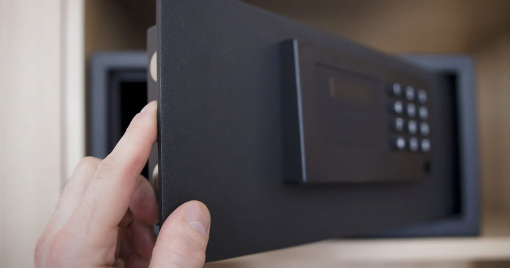 Man opens safe depository of valuables and money in his home. Keep the money in the safe at home. Safe, hand close-up