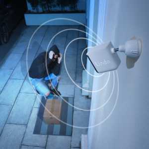 Package thief covering ears after triggering the Lindo security camera siren and visual alarm.