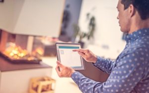 man pointing at smart home control app on a tablet