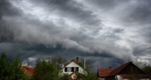 storm clouds gathering over the roofs of homes in a city
