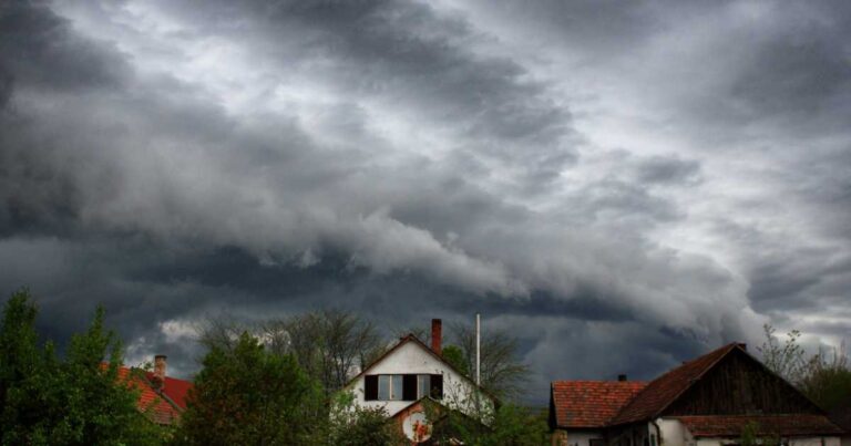 storm clouds gathering over the roofs of homes in a city