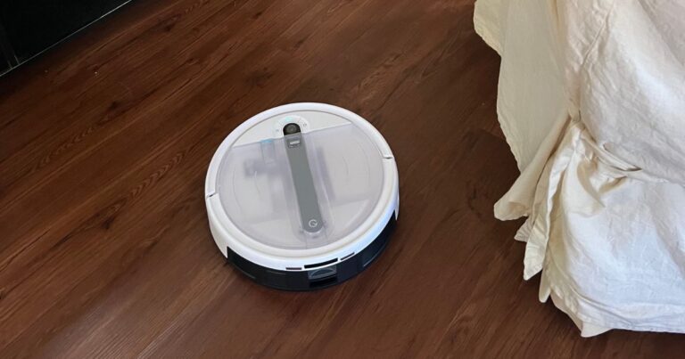 Yeedi cube cleaning wood floor near yellow chair